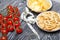 Cup with crackers, chips and measuring tape. Nearby lies a bunch of tomatoes. On brushed pine boards. Symbol of World No Diet Day