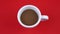 Cup of delicious coffee with milk on bright red background