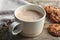 Cup with delicious hot cocoa drink and cookies