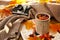 Cup of delicious mulled wine with autumn leaves on magazine