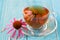 Cup of echinacea tea on blue wooden table