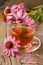 Cup of echinacea tea on old wooden table