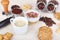 Cup of espresso, cappuccino with chocolate crumbs, cookies, crackers, holder with ground coffee, tamper and coffee beans on table