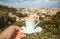 Cup of espresso coffee in hand of tourist and cityscape of Florence in perspective, Italy. Good morning concept