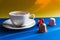 Cup of espresso coffee served with pods and capsules on bright blue background. side view.Beverage capsules for coffee mashine.