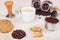 Cup of espresso, crackers, cookies, holder with ground coffee, tamper and coffee beans on table