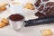 Cup of espresso, crackers, holder with ground coffee and cans of coffee beans on table