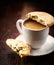 Cup of espresso crema and pistachio cookie on wooden background