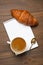 Cup of espresso, croissant and notepads, photo concept