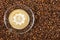 Cup of espresso with like sign on coffee foam on coffee beans background. With copy space