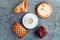 a cup of espresso on a saucer, buns and cakes on a wooden background.