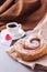 A cup of espresso on a saucer and a layered bun - a classic European or North American breakfast and a love letter in an envelope.