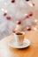 Cup of espresso or short coffee in white cup in cosy Christmas arrangement, festive decoration with white bokeh background, copy