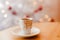 Cup of espresso or short coffee in white cup in cosy Christmas arrangement, festive decoration with white bokeh background, copy