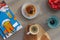 A cup of espresso on a wooden background and cakes with nuts and strawberries on a saucer on a gray background and a candle.