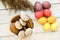 A cup filled with cookies is standing on a table beside a bunch of eggs and some wheat spikelets closeup