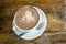 Cup of foamy cocoa beverage on wooden table