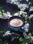 A Cup of fragrant freshly brewed coffee and blooming branches of spring cherries