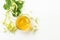 Cup of fresh herbal tea with blooming Tilia linden, basswood on white wooden background.