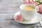 Cup of fresh morning coffee with pink carnation flowers on a wooden background. Valentine`s day concept.