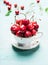 Cup with fresh ripe cherry berries, front view