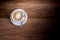 Cup of freshly brewed aromatic cappuccino standing on a wooden t