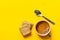 Cup of freshly brewed coffee with crema home baked bran cookies spoon on bright yellow background. Breakfast morning energy