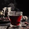 Cup of freshly brewed red karkade tea,rose tea ceremony, dark moody.Hot water is poured from the kettle into a flass cup on a