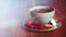 Cup of fruit tea with strawberries, raspberries and blueberries on wooden table, with copy space.