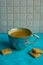 cup full of black coffee and small cookies laying on turquoise surface