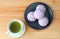 Cup of green tea with a plate of taro steamed buns on wooden table