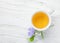 Cup of green tea and spring flower Periwinkle on light pink wooden table