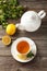 Cup with green tea and teapot on a grey wooden background