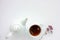 Cup of herbal oregano tea with dry marjoram flowers on white table background with copy space.