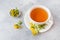 Cup with herbal tea from petals flowers Hypericum on grey background. Copy space