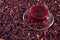 Cup of hibiscus tea in a dried petals of hibiscus