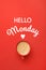 Cup of hot aromatic coffee and phrase Hello Monday on red background, top view