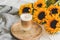 Cup with hot cappuccino, gray pastel woolen blanket, sunflowers, bedroom