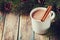 Cup of hot cocoa or hot chocolate on wooden background with fir tree and cinnamon sticks, traditional beverage for winter time