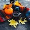 A Cup of hot coffee in the autumn Park. Knitted colorful warm scarf, pumpkin and maple leaves