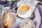 Cup of hot coffee, eclair and flowers on rustic wooden table, closeup photo warm sweater, winter morning concept.