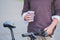 Cup of hot coffee in hands of a bicycle commuter.