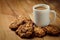 Cup with hot coffee and homemade backing chocolate cookies on a wooden table