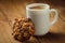 Cup with hot coffee and homemade backing chocolate cookies on a wooden table