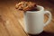 Cup with hot coffee and homemade backing chocolate cookies on a wooden table