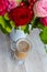 Cup of hot coffee with milk stands near the window and a bright colored bouquet of flowers