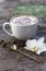 A cup of hot coffee and orchid flower on the wooden background. Traditional drink cappuccino or cocoa Wooden background Orchid flo