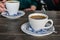 A cup of hot coffee on a table in a cafe. woman holding a cup of white latte