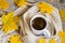 Cup of hot coffee, wrapped in scarf and colorful autumn maple leaves on wooden background