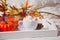 Cup of hot creamy cocoa with froth on the white tray with autumn leaves and pumpkins on the background